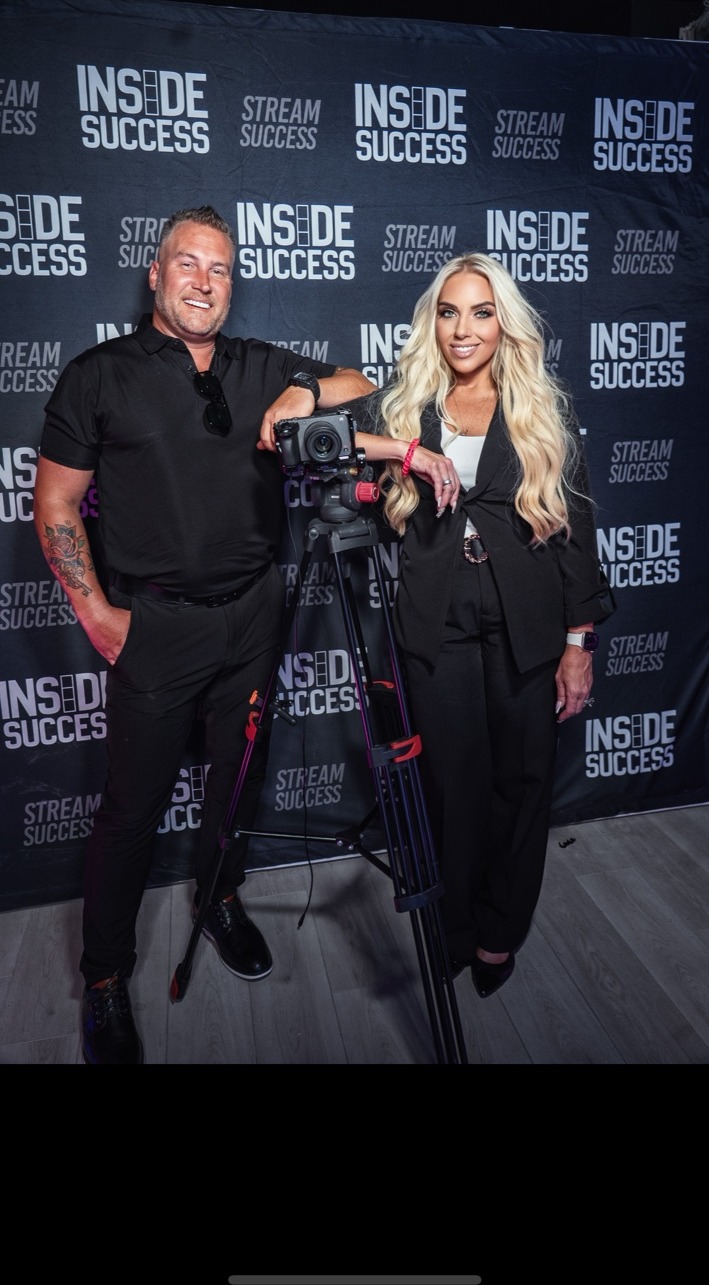 Laura Roark and Jamie Hale beside a professional video camera on a tripod at Inside Success